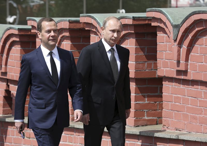 © Reuters. Presidente russo, Vladimir Putin (direita) caminha ao lado do primeiro-ministro do país, Dmitry Medvedev, para participar de uma cerimônia na Tumba do Soldado Desconhecido, em Moscou