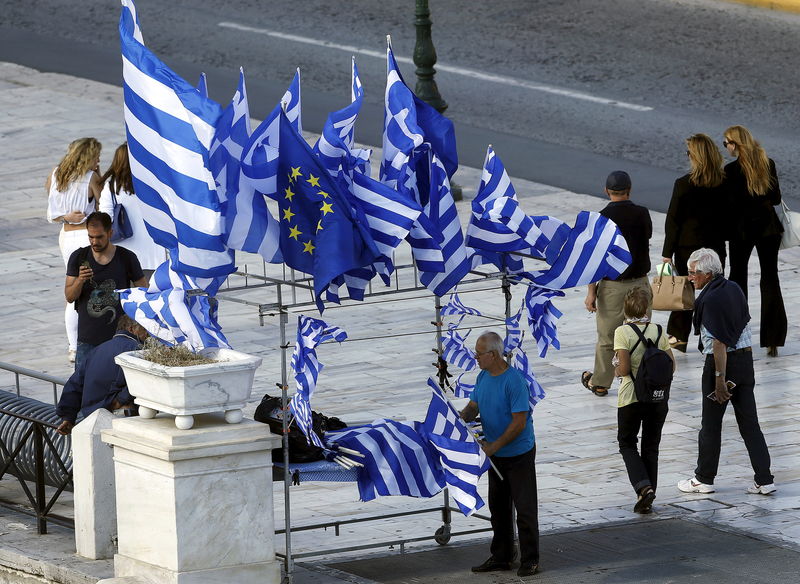 © Reuters. Vendedor ambulante com bandeiras da Grécia e da UE, em Atenas