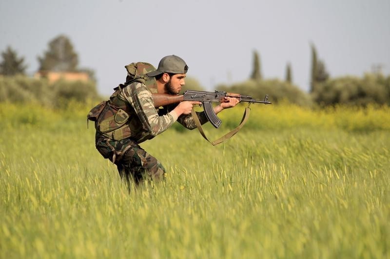 © Reuters. A rebel fighter aims weapon as he takes position during military training in Aleppo's countryside