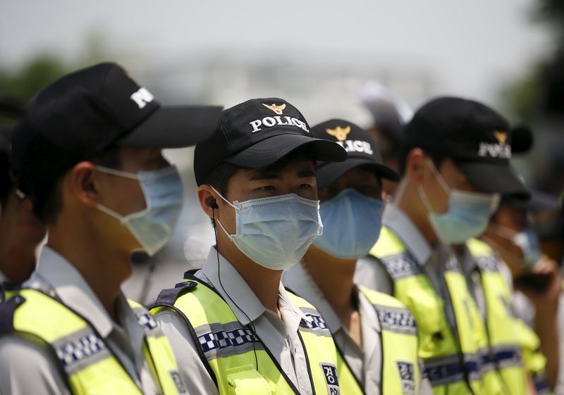 © Reuters. Policiais usam máscaras na Coreia do Sul para evitar se contaminarem com Mers