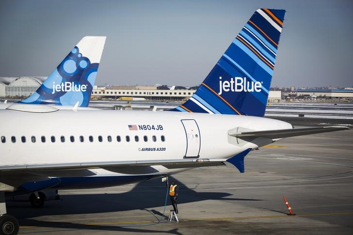 © Reuters. An airport worker fuels a JetBlue plane on the tarmac of the John F. Kennedy International Airport in New York