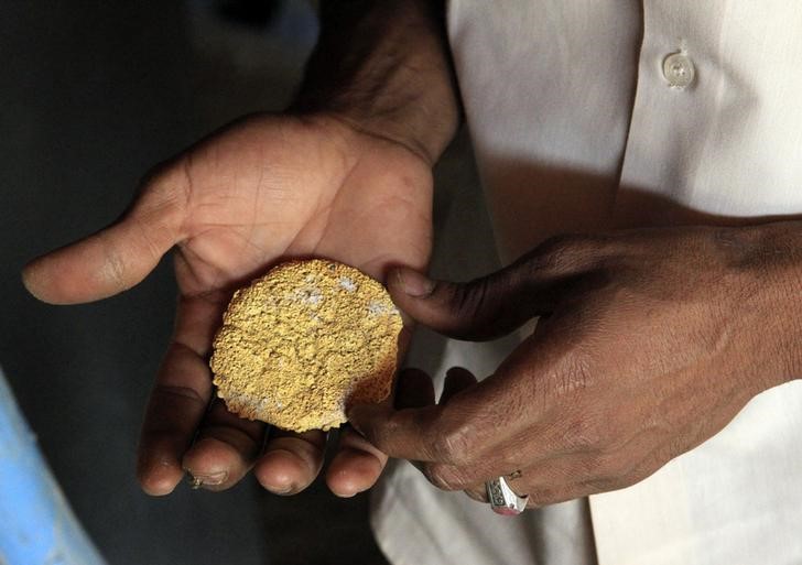 © Reuters. A worker holds gold ore at the Wad Bushara gold mine near Abu Delelq in Gadarif State, Wad Bushara