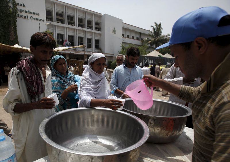 © Reuters. Pessoas recebendo água em Karachi, no Paquistão