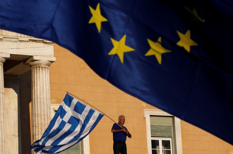 © Reuters. Manifestante agita bandeira da Grécia na entrada do Parlamento durante protesto, em Atenas