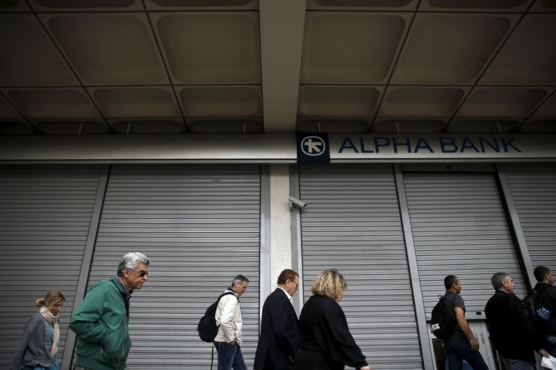 © Reuters. People make their way past a closed Alpha Bank branch in Athens