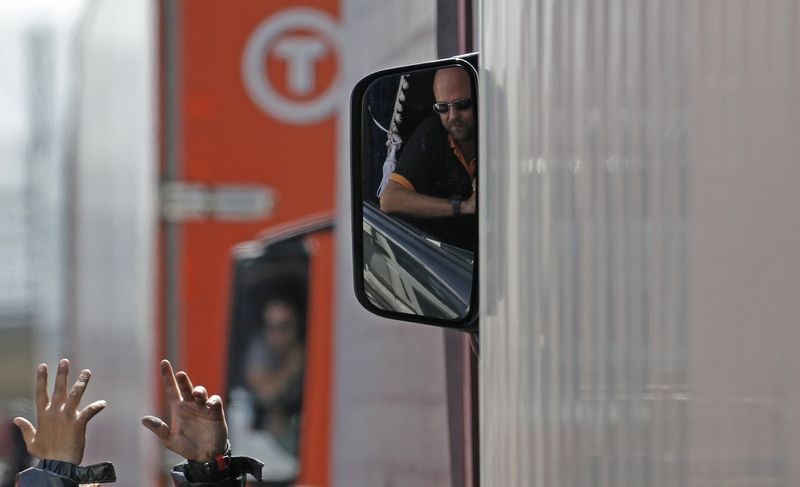 © Reuters. A migrant argues with a truck driver as lorries wait in line on the motorway which leads to the Channel Tunnel terminal in Calais