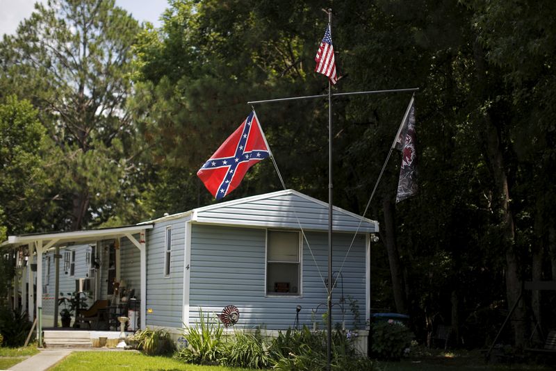 © Reuters. Bandeira de batalha dos confederados e bandeira dos EUA em casa em Summerville, Carolina do Sul 