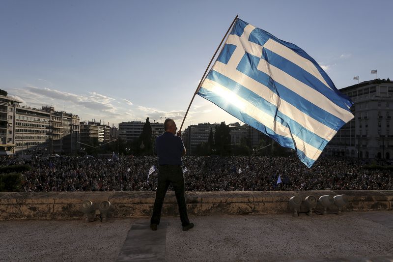 © Reuters. Homem agita a bandeira da Grécia durante manifestação na frente do Parlamento, em Atenas