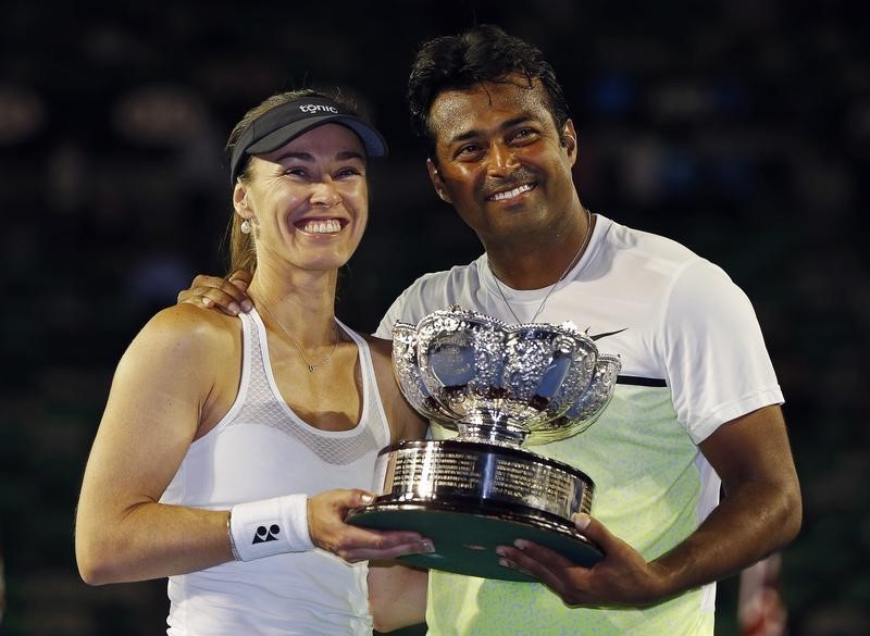 © Reuters. Hingis of Switzerland and Paes of India pose with their trophy after defeating Mladenovic of France and Nestor of Canada to win their mixed doubles final match at the Australian Open 2015 tennis tournament in Melbourne