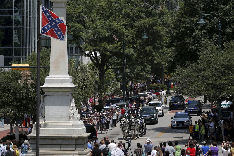 © Reuters. A horse drawn carriage carries the casket of the late South Carolina State Senator Clementa Pinckney past the Confederate flag and onto the grounds of the South Carolina State Capitol in Columbia