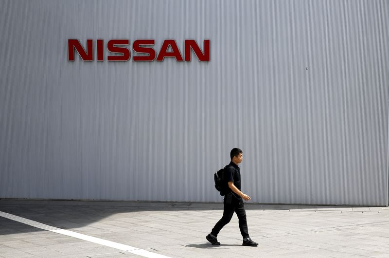 © Reuters. Man walks past logo of Nissan Motor Co. at the company's showroom in Yokohama