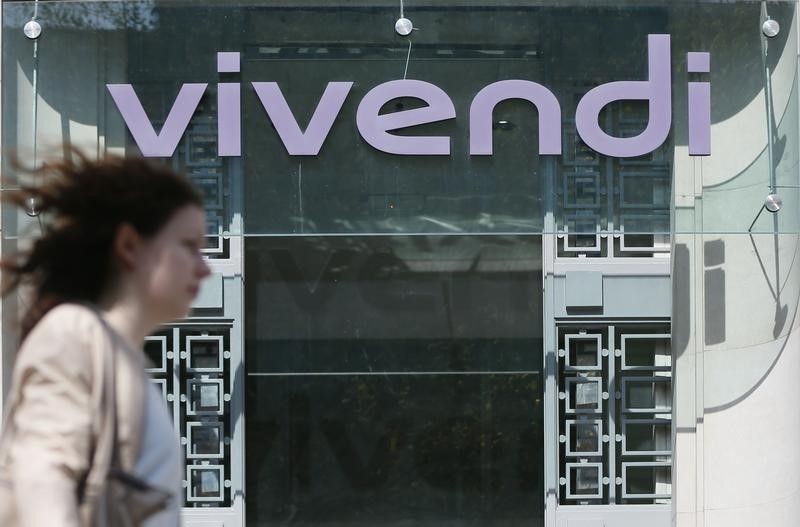 © Reuters. A woman walks walk past the main entrance of the entertainment-to-telecoms conglomerate Vivendi's headquarters in Paris