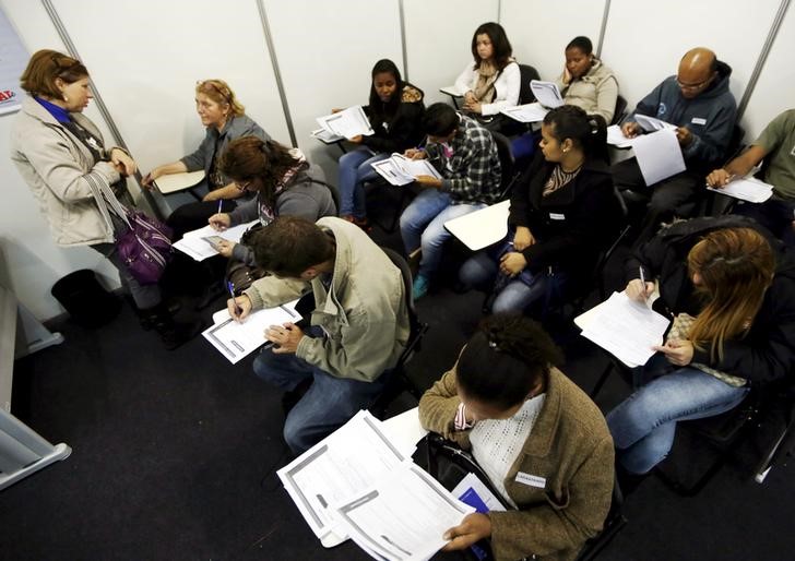 © Reuters. Desempregados preenchem fichas de inscrição em busca de emprego em São Paulo