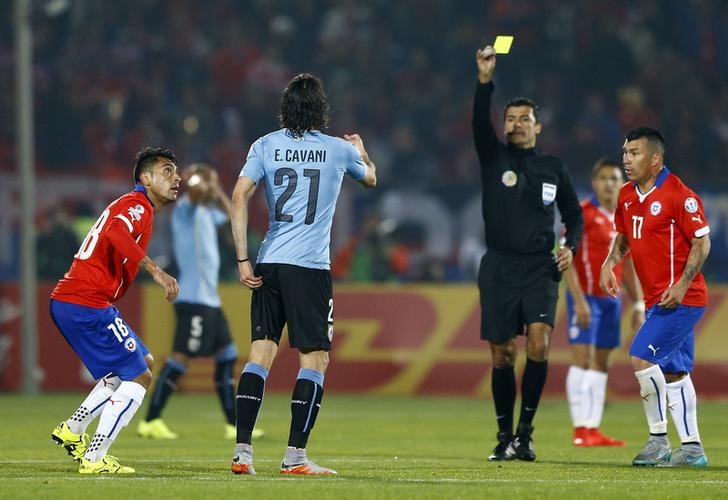 © Reuters. Árbitro brasileiro Sandro Ricci mostra segundo cartão amarelo para atacante Edinson Cavani, do Uruguai, durante partida contra o Chile pela Copa América, em Santiago