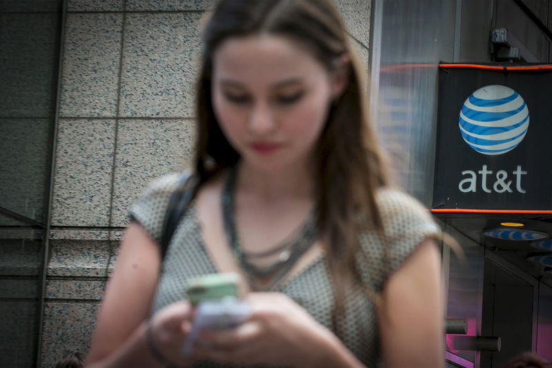© Reuters. A woman uses her phone outside the AT&T store in New York's Times Square