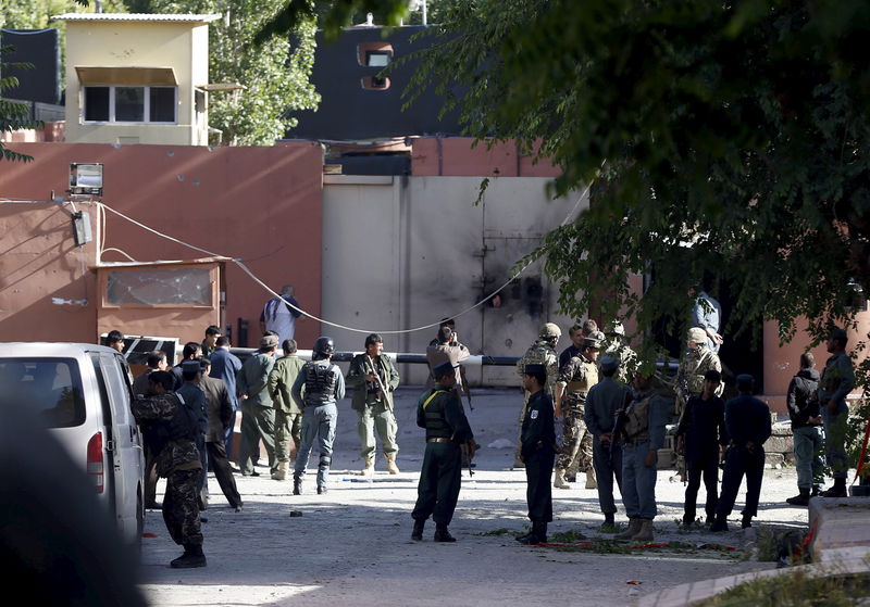 © Reuters. Afghan security force stand at the gate of a guesthouse after an attack in Kabul 