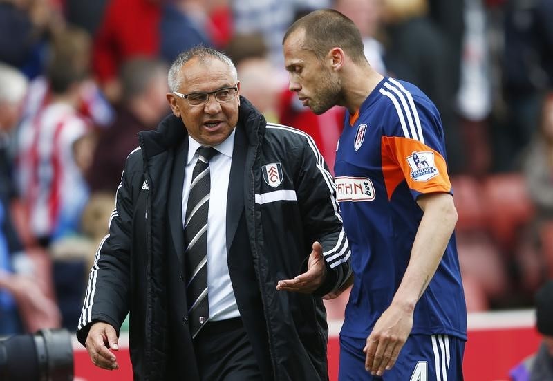 © Reuters. Fulham manager Felix Magath speaks to John Heitinga as they walk off at half time during their English Premier League soccer match against Stoke City at the Britannia stadium in Stoke