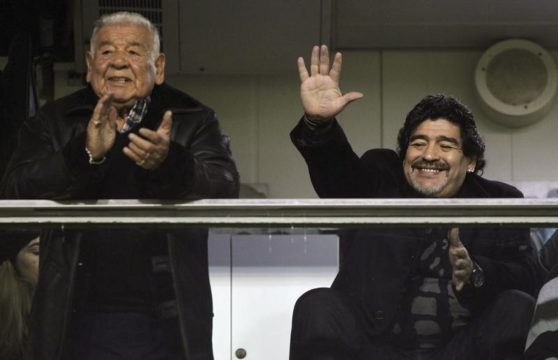 © Reuters. Ex-jogador argentino Diego Maradona acena ao lado do pai