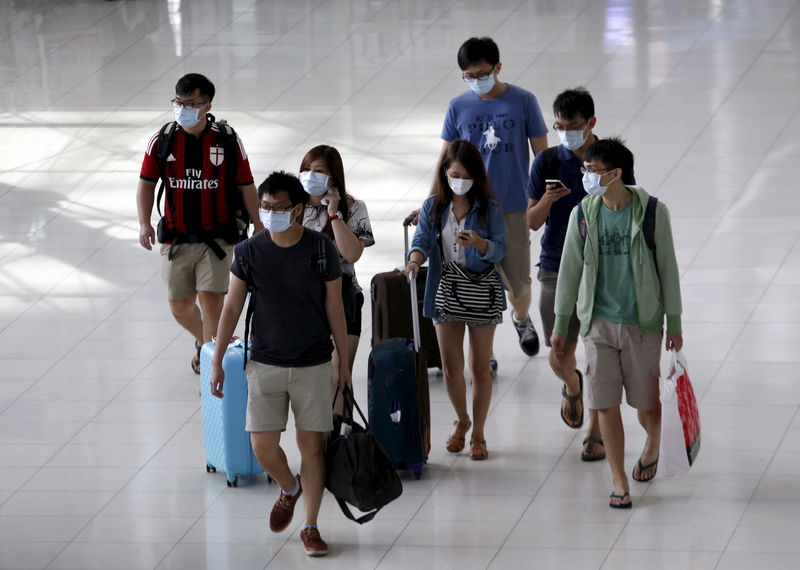 © Reuters. A group of tourists wear masks to prevent contracting Middle East Respiratory Syndrome (MERS) as they arrive at Bangkok's Suvarnabhumi International Airport