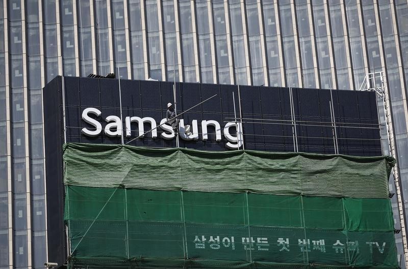 © Reuters. A worker works on a Samsung outdoor advertisement installed atop an office building in central Seoul