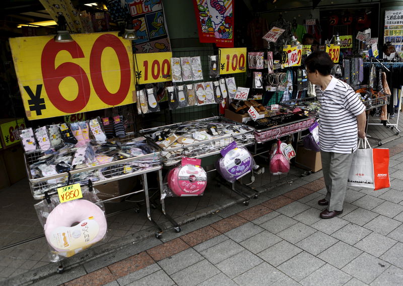 © Reuters. A shopper looks at items outside a discount store at a shopping district in Tokyo