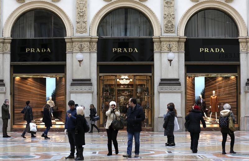 © Reuters. Persone a passeggio tra le vetrine a Milano 