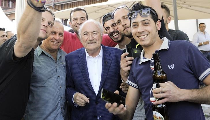 © Reuters. Presidente da Fifa, Joseph Blatter, posa com trabalhadores durante evento com operários das obras do museu da Fifa, em Zurique