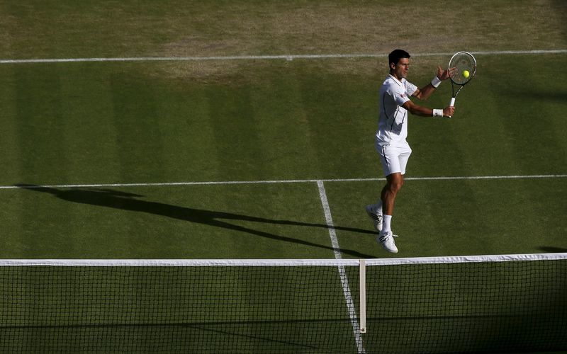 © Reuters. File photo shows Novak Djokovic hitting a volley to Jeremy Chardy in their men's singles tennis match at the Wimbledon Tennis Championships, in London