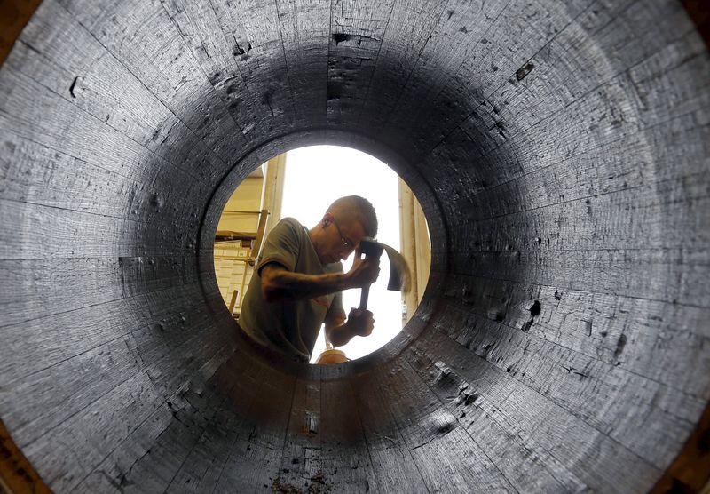 © Reuters. An employee works on an oak barrel in a workshop at the Hennessy factory in Cognac, France