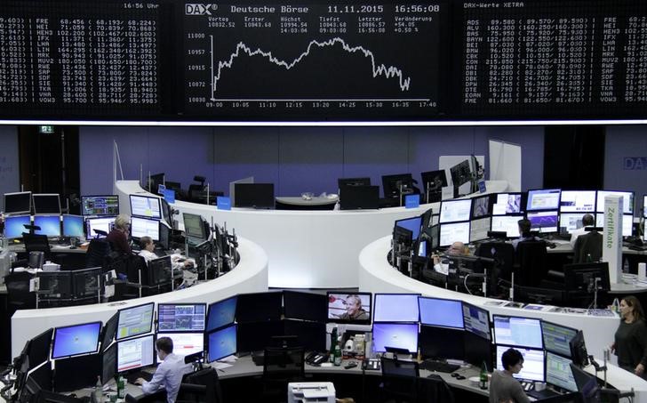 © Reuters. Traders are pictured at their desks in front of the DAX board at the Frankfurt stock exchange