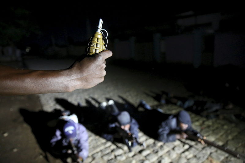 © Reuters. An armed vigilante holds a Soviet made hand grenade in the center of Bujumbura, Burundi