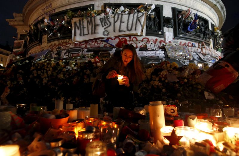 © Reuters. Mulher acende uma vela na Praça da República, em Paris, após série de atentados