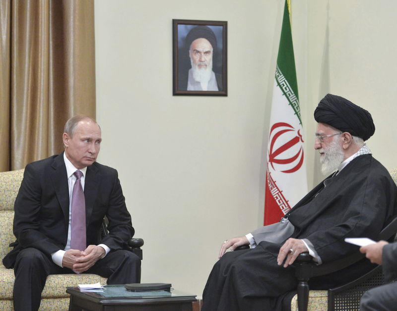 © Reuters. Presidente da Rússia, Vladimir Putin (E), conversa com líder supremo do Irã, aiatolá Ali Khamenei, durante reunião em Teerã 