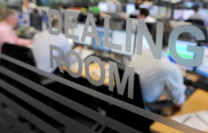 © Reuters. Traders work on a dealing room floor at CMC Markets in the City of London