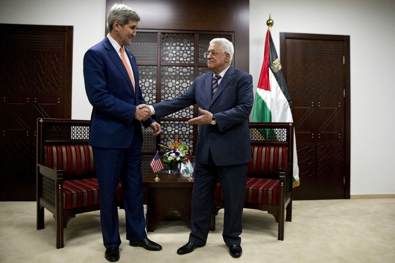 © Reuters. Palestinian President Mahmoud Abbas invites U.S. Secretary of State John Kerry to take a seat for their meeting in the West Bank city of Ramallah