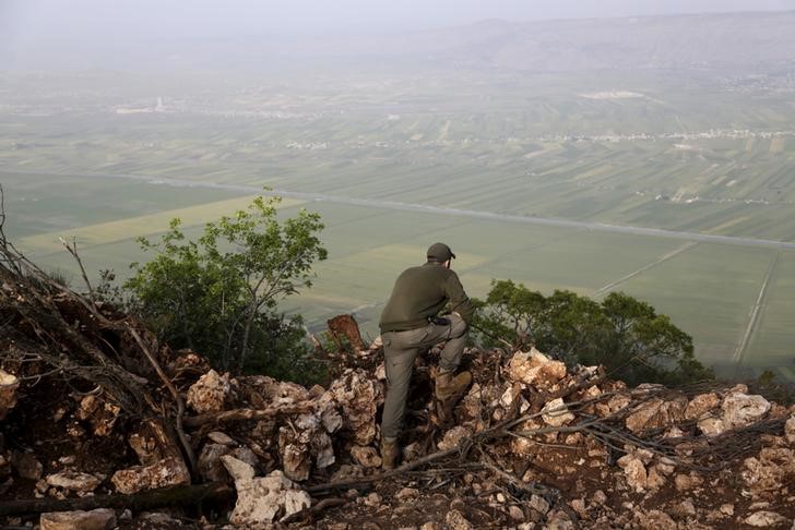 © Reuters. Membro das Forças sírias observando a província de Latakia, onde o avião de guerra russo caiu