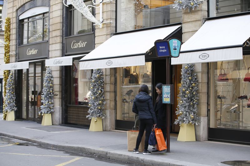 © Reuters. Customers stand on an uncrowded sidewalk in front of shops selling luxury goods rue du faubourg Saint-Honore in Paris after last Friday's series of deadly attacks in the French capital, France