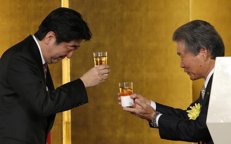 © Reuters. Japan's PM Abe and Keidanren's Chairman Sakakibara toast at a New Year party hosted by the Japan Business Federation, Japan Association of Corporate Executives and Japan Chamber of Commerce and Industry, in Tokyo