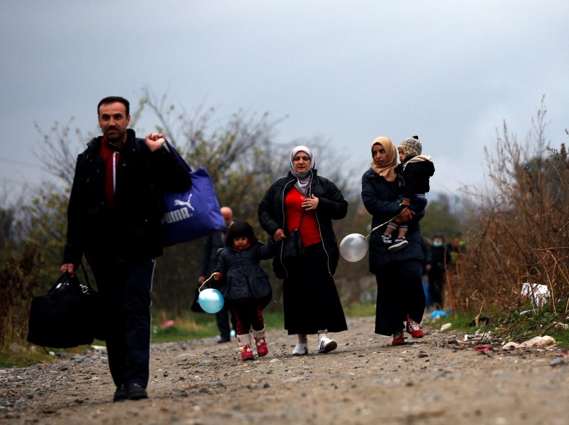 © Reuters. Migrants walk after crossing the border from Greece into Macedonia, near Gevgelija