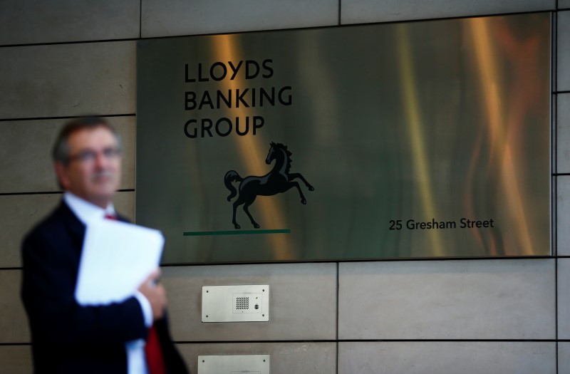© Reuters. A man waits outside the corporate headquarters of Lloyds Banking Group in the City of London