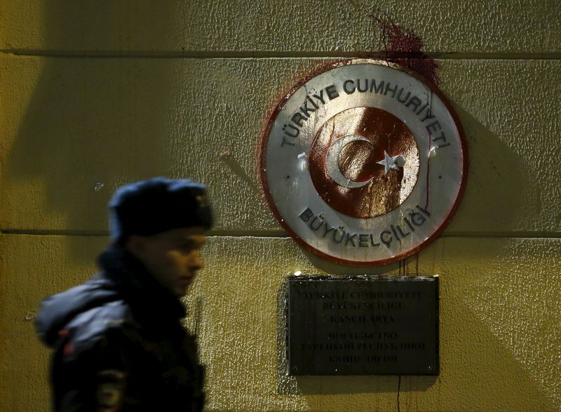 © Reuters. Policeman walks past sign of Turkish embassy stained by protesters in reaction after Russian war plane was shot down by Turkey in Moscow