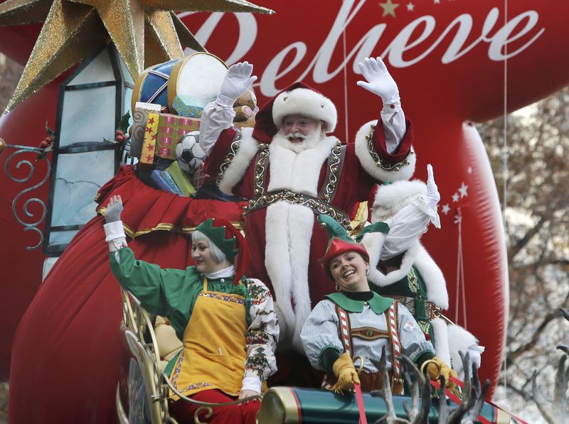 © Reuters. A float carrying Santa and his elves waves to spectators along 6th Ave during the 89th Macy's Thanksgiving Day Parade in the Manhattan borough of New York 
