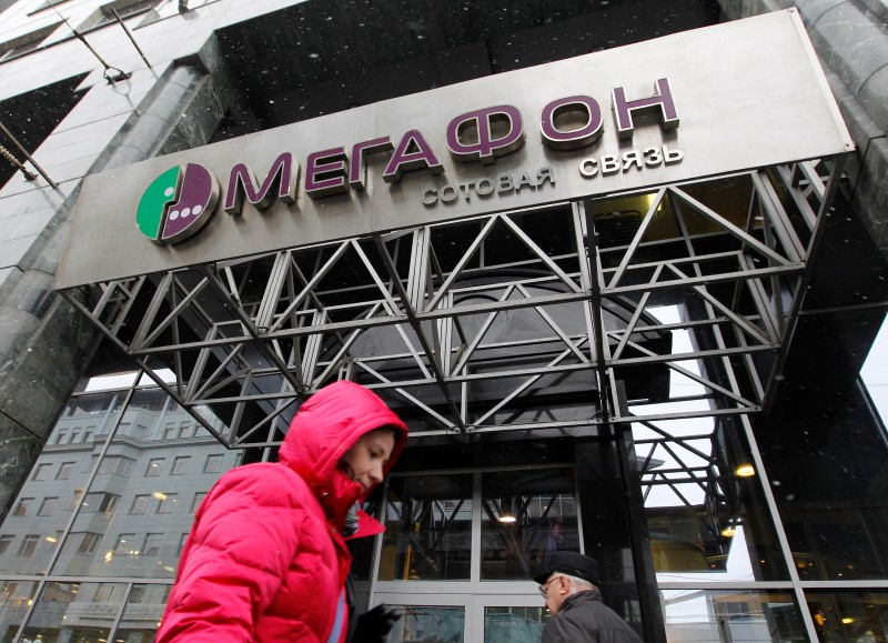 © Reuters. People pass by a MegaFon office in Moscow