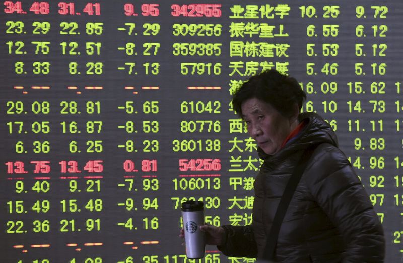 © Reuters. Инвестор на фоне электронного табло в брокерской фирме в Ханчжоу, Китай