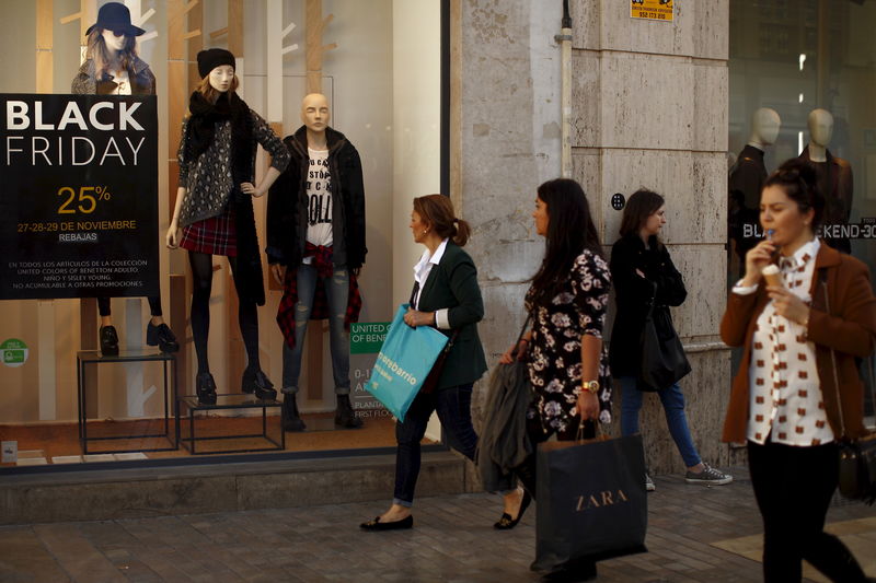 © Reuters. Women carry shopping bags during the Black Friday sales in downtown Malaga