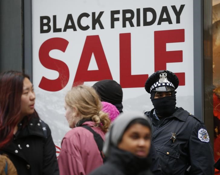 © Reuters. Policial para em frente a uma loja em Chicago, enquanto consumidores passam durante um protesto  motivado pela morte do adolescente negro Laquan McDonald, por um policial no ano passado. 