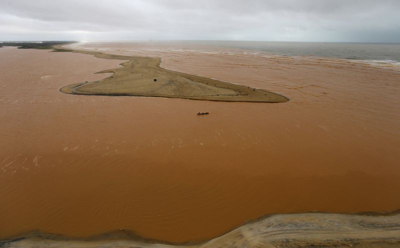 © Reuters. Um barco é visto na foz do Rio Doce, que foi inundado com lama após uma barragem da mineradora Samarco ter se rompido.