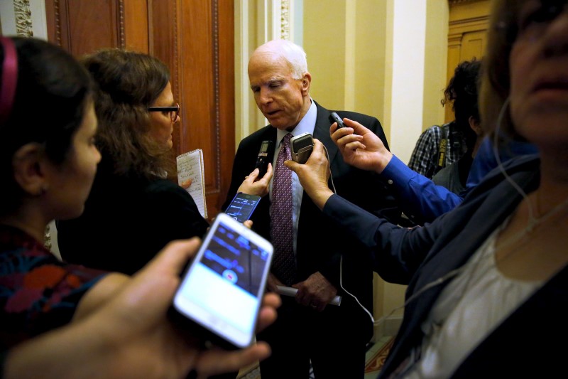 © Reuters. McCain speaks with a reporter after the weekly Republican caucus luncheon at the U.S. Capitol in Washington