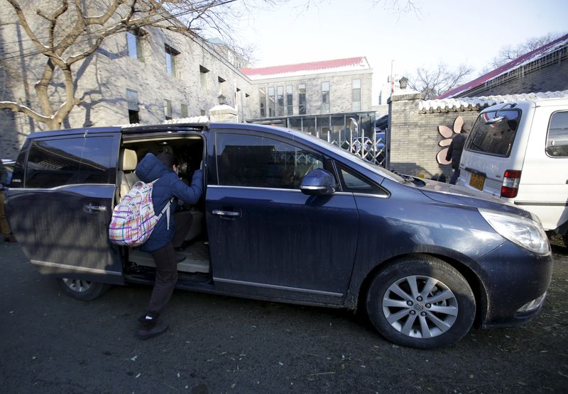 © Reuters. A primary school student gets into a minivan as her mother picks her up outside her school, in Beijing