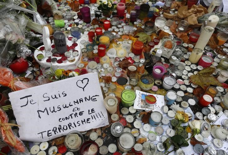 © Reuters. A message which reads" I am a Muslim who is against terrorism" is seen among candles in tribute to victims near the Bataclan concert hall in Paris